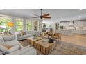 Spacious living room featuring a ceiling fan, large windows, hardwood floors, and an open view to the kitchen at 814 Covered Bridge Trl, Chapel Hill, NC 27517