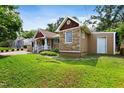 Well-maintained house showcasing stone accents, a tidy lawn, and a detached garage at 821 Woodburn Rd, Raleigh, NC 27605