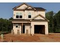 Two-story home under construction showing the frame with garage and a partially bricked foundation at 95 Goldenrod Loop, Clayton, NC 27520