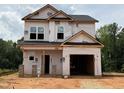 Unfinished two-story home with visible framework, siding wrap, and a two car garage awaiting completion at 95 Goldenrod Loop, Clayton, NC 27520