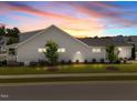 Exterior view of home showcasing lush lawn, manicured landscaping and attached side porch at 1000 Groveview Wynd, Wendell, NC 27591