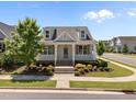 Inviting curb appeal with landscaped front yard, covered porch, dormer windows and street view at 1000 Groveview Wynd, Wendell, NC 27591