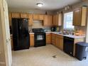 Functional kitchen with black appliances, ample wooden cabinetry, and a classic layout at 104 Holly Ranch Ct, Willow Springs, NC 27592
