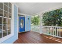 Inviting front porch with stained wood flooring, blue siding, white railing, and ample space for relaxing at 104 Shady Ridge Ct, Apex, NC 27502