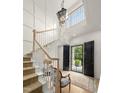 Bright foyer featuring a staircase, light hardwood floors, decorative rug, and black double doors at 115 Founders Ridge Dr, Chapel Hill, NC 27517