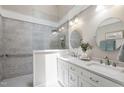 Modern bathroom featuring double sinks, sleek countertops, and a stylish glass-enclosed shower with gray tiling at 115 Heatherwood Dr, Apex, NC 27502