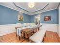 Dining room featuring hardwood floors, wainscoting and a large wooden table set with blue accents at 1230 Golden Bluff Ln, Fuquay Varina, NC 27526