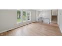 Open-concept living room featuring new hardwood floors, a view to the staircase and an oversized window at 1308 Swallow Dr, Raleigh, NC 27606