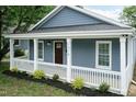 Beautiful blue home with a cozy front porch, white railings, and green lawn at 1318 N Alston Ave, Durham, NC 27701