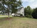 Landscaped front yard leading to a well-maintained two-story home with a charming covered entry at 148 Langston Ridge Dr Dr, Angier, NC 27501