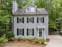 Two-story home with light gray siding, black shutters, dormer windows, and a chimney at 15 Gray Fox Ct, Durham, NC 27713