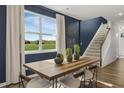 Elegant dining room featuring a large window with natural light and a modern staircase at 157 Vaughan Farms Drive Dr, Angier, NC 27501