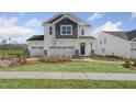 Attractive two-story home with a lush green lawn, brick walkway, and a convenient three-car garage at 157 Vaughan Farms Drive Dr, Angier, NC 27501