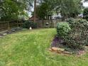 Spacious backyard with a green lawn, mature trees, and a wooden fence, offering a private outdoor space at 1615 Bickett Blvd, Raleigh, NC 27608