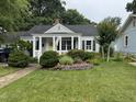 Well-maintained home featuring a lush front yard, flower beds, and a charming covered entry at 1615 Bickett Blvd, Raleigh, NC 27608
