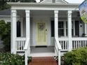 Inviting front porch with classic white columns, a decorative door, and a cozy atmosphere at 1615 Bickett Blvd, Raleigh, NC 27608