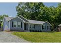 Well-maintained home featuring blue siding, black shutters, and a neatly landscaped lawn at 169 Forest Dr, Graham, NC 27253