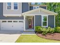 Close up of a beautiful home featuring a striking red front door and attached two-car garage at 187 Harpers Landing Rd, Garner, NC 27529