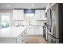 White kitchen with an island, stainless steel appliances, and wood floor at 206 Bluebell St, Sanford, NC 27330