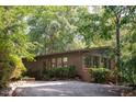 Attractive single story home, rear view, with a brick accent and surrounded by mature trees at 26 Mt. Bolus Rd, Chapel Hill, NC 27514