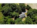 Aerial view of a home nestled among trees, featuring a large yard and driveway at 2642 Holly Springs Church Rd, Broadway, NC 27505