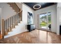 Elegant foyer with herringbone wood floors, a staircase, and a large window offering scenic views at 2713 Trifle Lane Ln, Wake Forest, NC 27587
