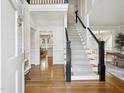 Bright foyer with hardwood floors, staircase, and view of kitchen at 305 Promontory Point Dr, Cary, NC 27513
