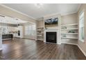 Open-concept living room featuring a fireplace, floating shelves, and wood flooring at 316 Levi Ln, Wake Forest, NC 27587