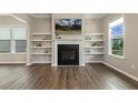 Inviting living room featuring a fireplace, floating shelves, and wood flooring at 316 Levi Ln, Wake Forest, NC 27587