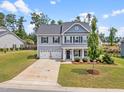 Aerial view of a two-story home with manicured lawn, landscaping, and two-car garage at 33 E Ravano Dr, Clayton, NC 27527