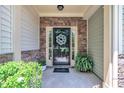 Inviting front door entrance with stone accents, decorative wreath, and lush potted plants for a welcoming feel at 342 Westgrove Ct, Durham, NC 27703
