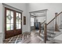 Stunning foyer with wood floors, glass front doors, staircase, and designer accents at 4105 Bankshire Ln, Raleigh, NC 27603