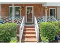 Inviting front porch and entrance featuring brick steps, decorative planters, and a charming front door with wreath at 4604 Townesbury Ln, Raleigh, NC 27612