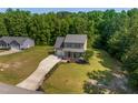 Aerial view of a charming two-story home on a spacious lot, surrounded by lush greenery and mature trees at 486 S Denise Ave, Coats, NC 27521