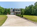 Two-story home with a long driveway, a covered front porch, and landscaped with green shrubbery and rock borders at 486 S Denise Ave, Coats, NC 27521