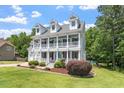 Charming two-story white home featuring a spacious front porch and well-manicured lawn at 513 Lake Gaston Dr, Fuquay Varina, NC 27526