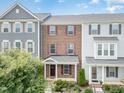 Brick townhome boasting colorful shutters, well-kept landscaping, and a welcoming front porch at 5908 Giddings St, Raleigh, NC 27616