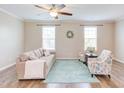 Cozy living room boasts a ceiling fan, neutral tones, and a soft area rug over hardwood floors at 5908 Giddings St, Raleigh, NC 27616