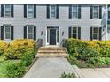 Close-up of the home's entrance with stone steps, black door, and decorative landscaping at 6201 Bayswater Trail Trl, Raleigh, NC 27612