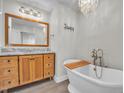 Luxurious bathroom featuring a soaking tub and a wooden vanity at 6328 Jones Farm Rd, Wake Forest, NC 27587