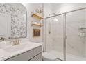 Elegant bathroom with a glass-enclosed shower, floating shelves, and stylish floral wallpaper at 74 Permit Ct, Chapel Hill, NC 27517
