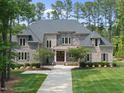 Stately two-story home featuring brick and stone accents, a well-manicured lawn, and a welcoming walkway at 7545 Hasentree Club Dr, Wake Forest, NC 27587