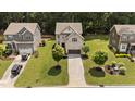 Beautiful home in a well-kept neighborhood with lush green lawns and mature trees at 8132 Wheeler Woods Dr, Apex, NC 27539