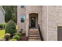 Close-up of the front entrance with brick stairs and manicured landscaping at 8132 Wheeler Woods Dr, Apex, NC 27539
