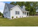 Landscaped yard and inviting covered porch accentuates the side exterior of this single-Gathering home at 820 Water Plant Rd, Zebulon, NC 27597