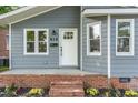 A close-up of the front door with brick steps and manicured landscaping with flowers at 828 Cotton Pl, Raleigh, NC 27601