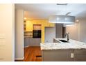 Bright, spacious kitchen with grey cabinets, stainless appliances, and wood flooring at 90 Oak Leaf Ln, Chapel Hill, NC 27516