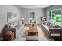 Bright living room with large windows, plush seating, stylish decor, and a cozy rug creating an inviting space at 916 Waring St, Durham, NC 27704