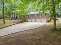 An expansive driveway leads to a stunning brick home with an attached three car garage at 9801 Honeycutt Rd, Raleigh, NC 27614