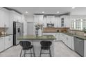 Modern kitchen with stainless steel appliances, white cabinets, an island and tile flooring at 101 Quarryrock Rd, Holly Springs, NC 27540